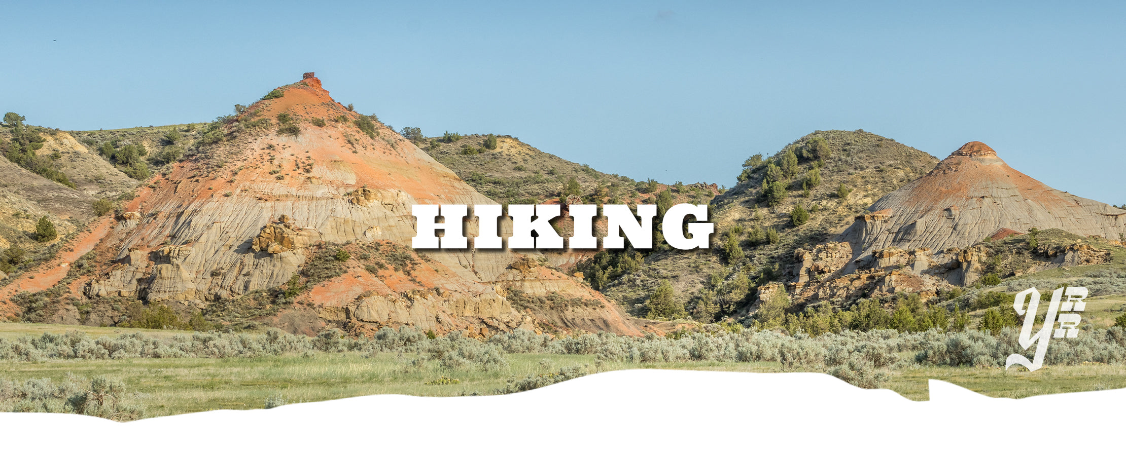 Scenic landscape with Badlands red rock formations and the word 'Hiking' overlayed.