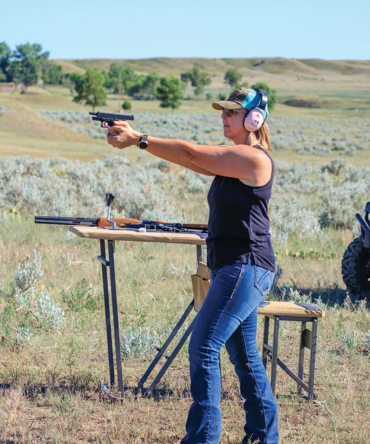 Person practicing shooting in an outdoor field with a clear sky.