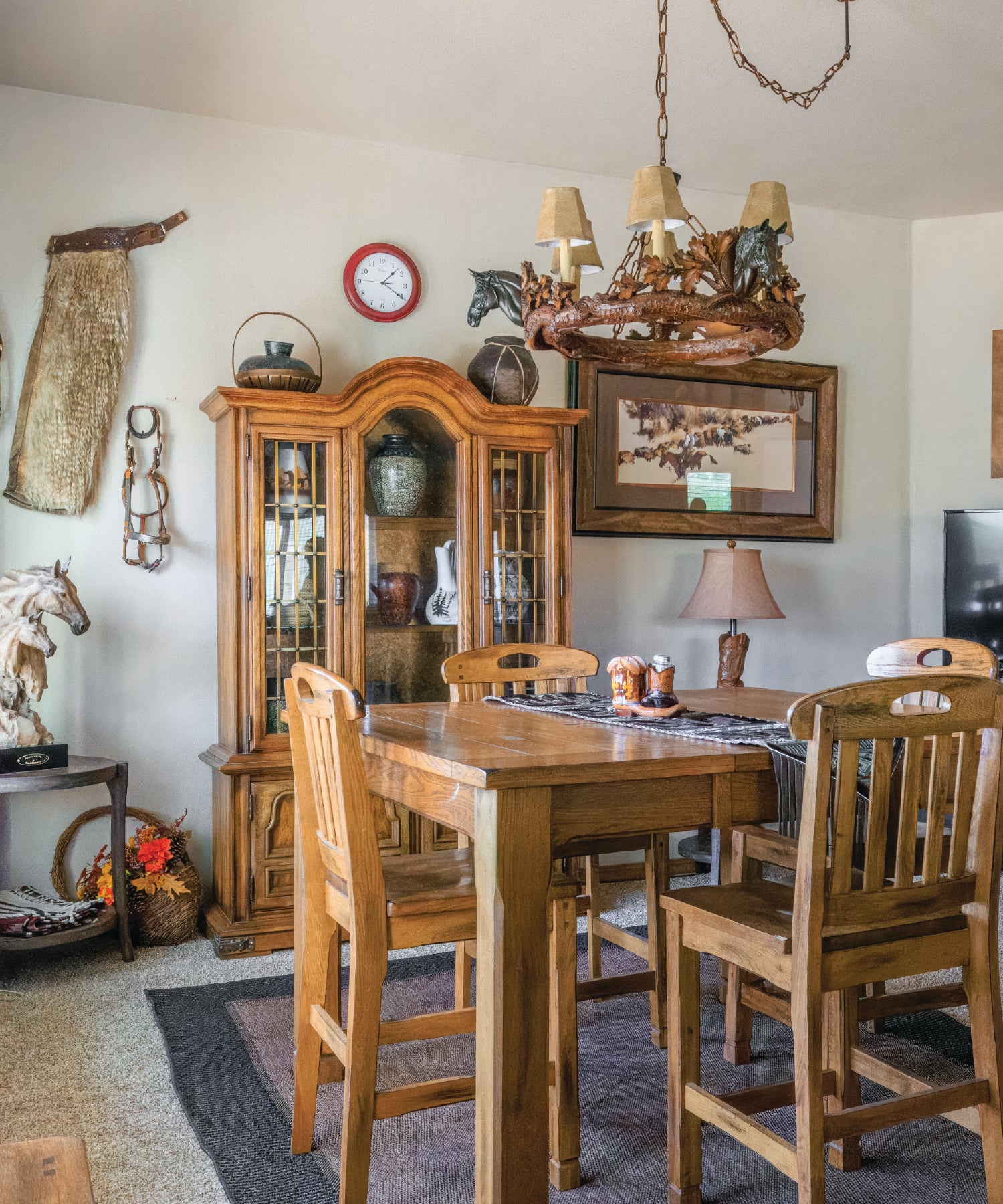 Rustic dining room with wooden table and chairs, china cabinet, and decorative items on the walls.