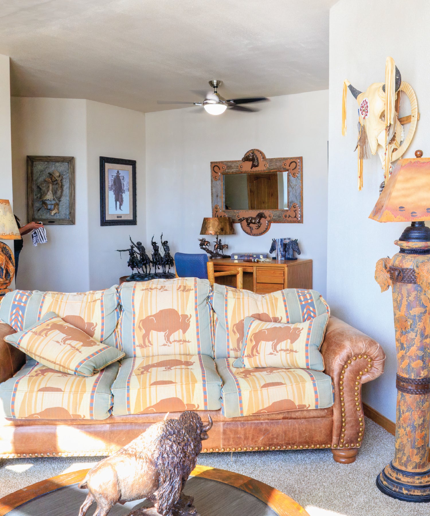 Living room with patterned sofa, decorative pillows, and tribal-themed decor.