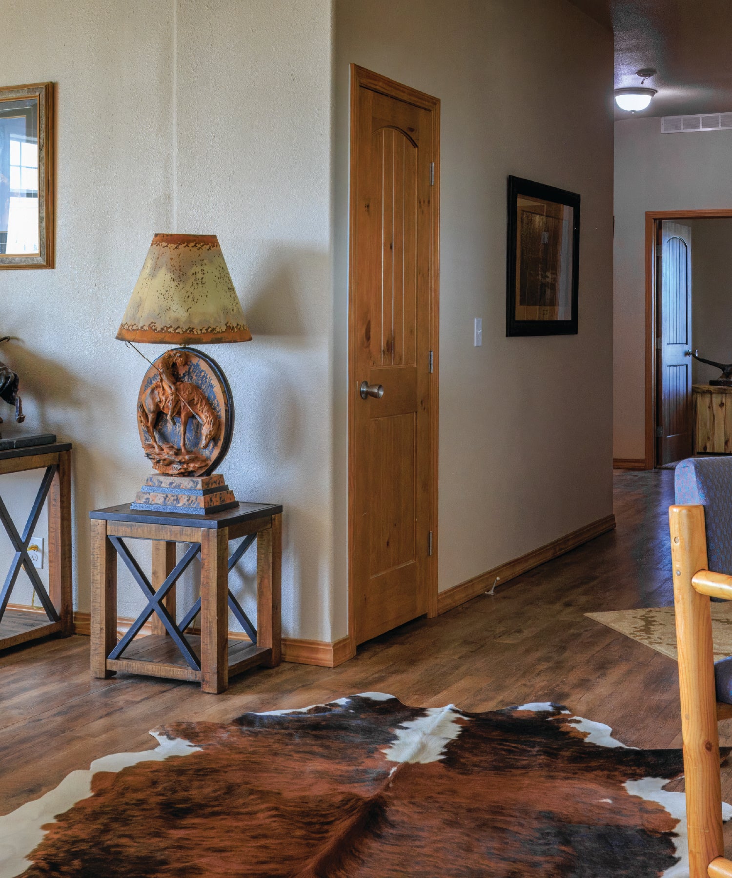 Rustic living room with wooden table, lamp, and cowhide rug