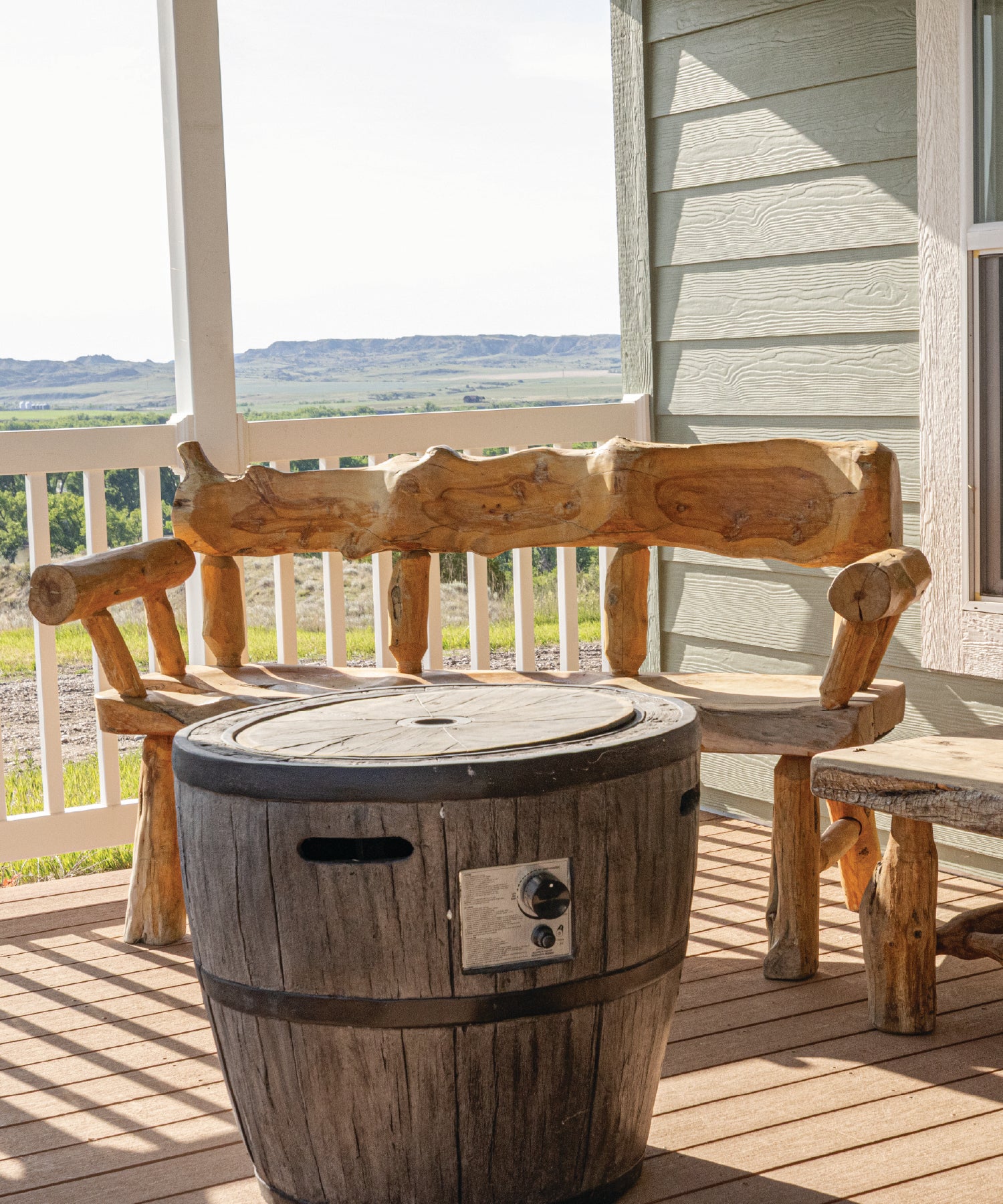 Wooden barrel fire pit on a porch with a scenic view
