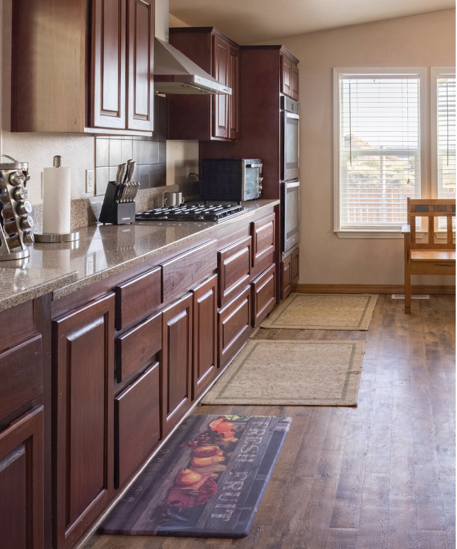 Kitchen with wooden cabinets, granite countertops, and a window.