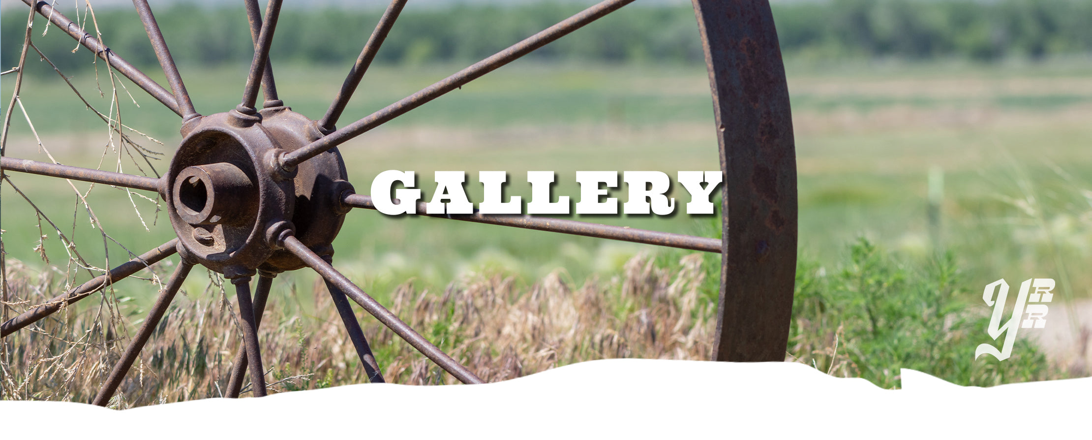 Rustic wagon wheel with 'GALLERY' text overlay on a natural background