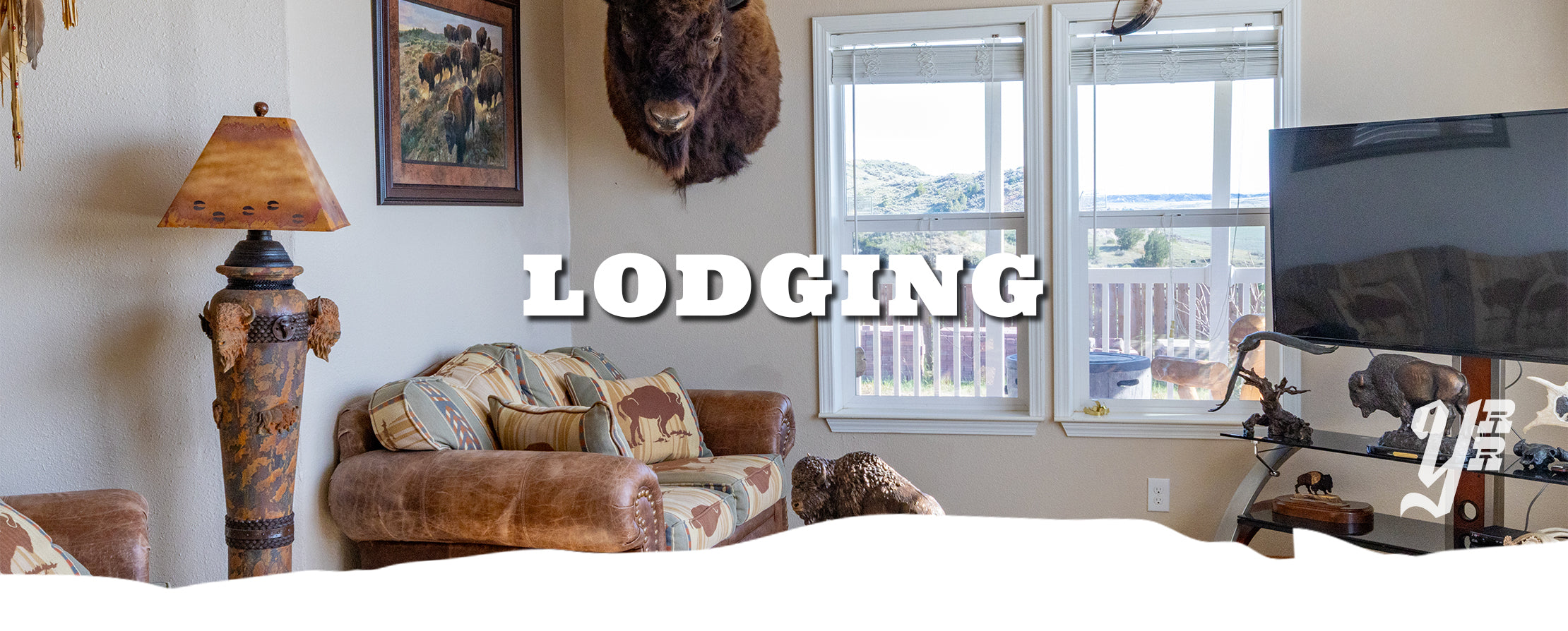 Living room with a couch, lamp, and window, featuring the word 'Lodging'.