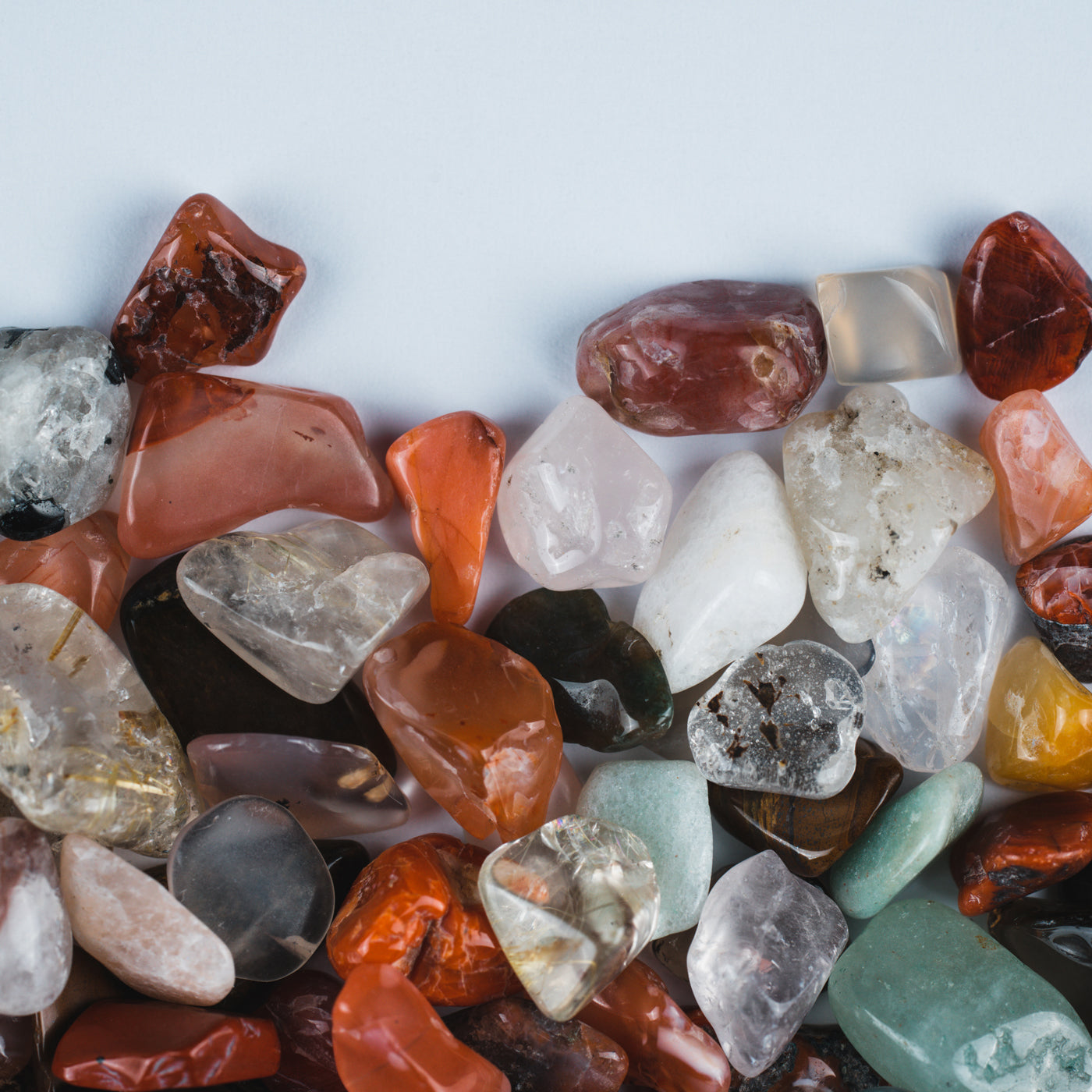 Assorted colorful gemstones on a light gray background